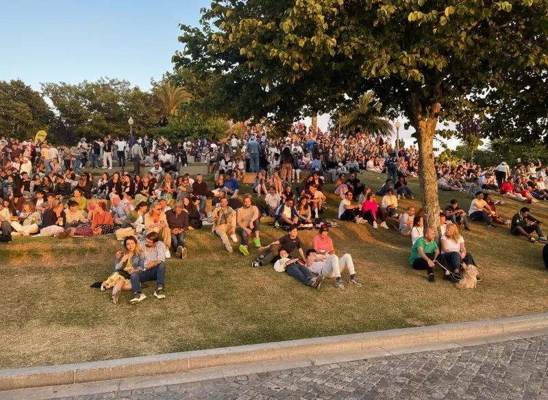 Gente reunida en el Jardim do Morro en Vila Nova de Gaia, Oporto, disfrutando del atardecer con vistas a la Ribeira y el río Duero.