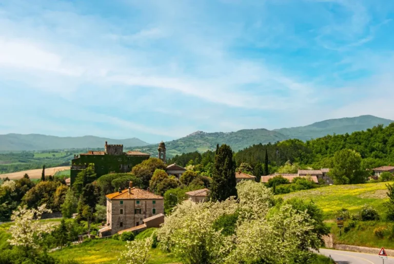 Paisaje de colinas verdes y cipreses en el Val d'Orcia al atardecer, ideal para viajar a la Toscana.
