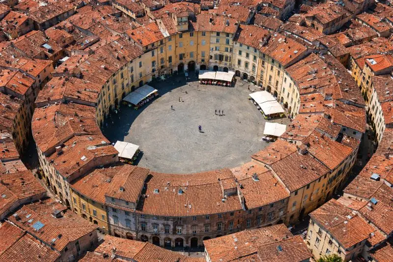 Vista de la Plaza del Anfiteatro de Lucca con su característica forma ovalada y casas medievales de colores