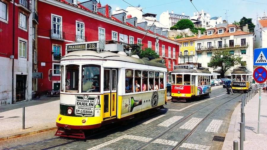 Calle del barrio de Alfama en Lisboa con tranvía amarillo
