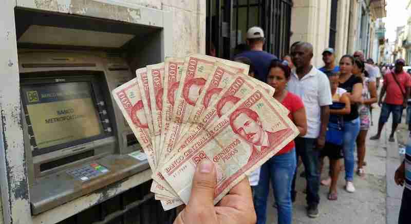 Persona sacando pesos cubanos en un cajero de La Habana.