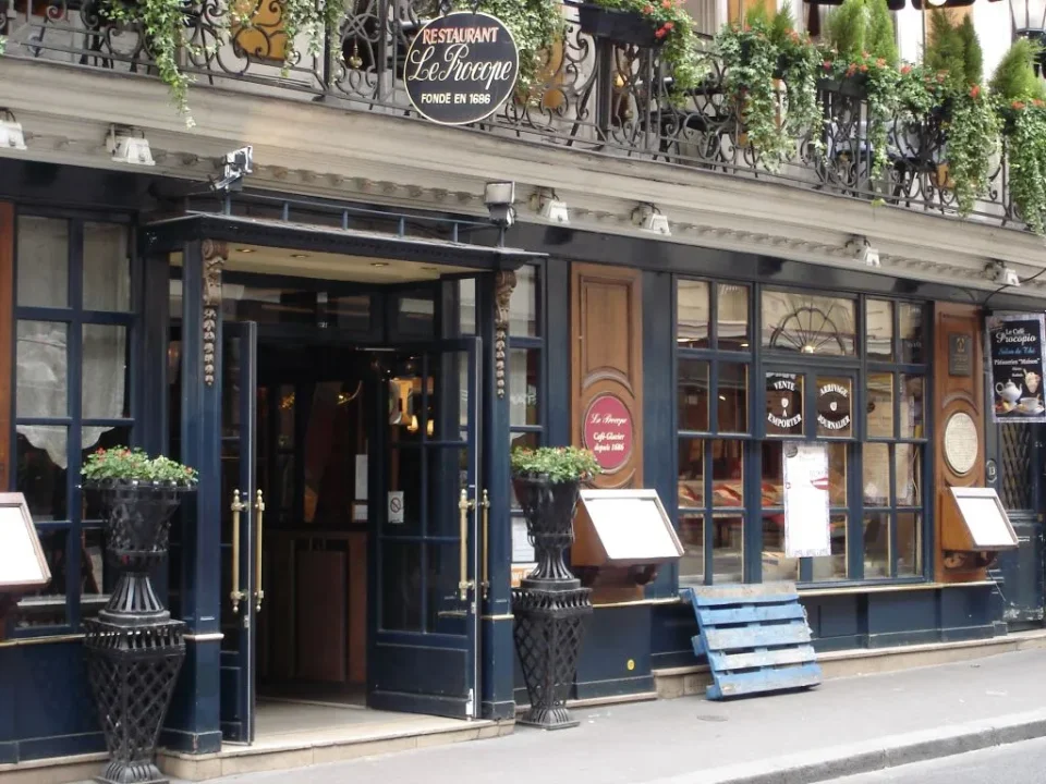 Interior del Café Le Procope decoración clásica con espejos y lámparas de época