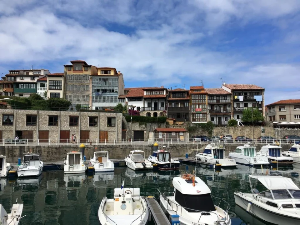 El puerto y el casco antiguo de Llanes con barcos y edificios coloridos, una parada pintoresca en tu ruta por el norte de España