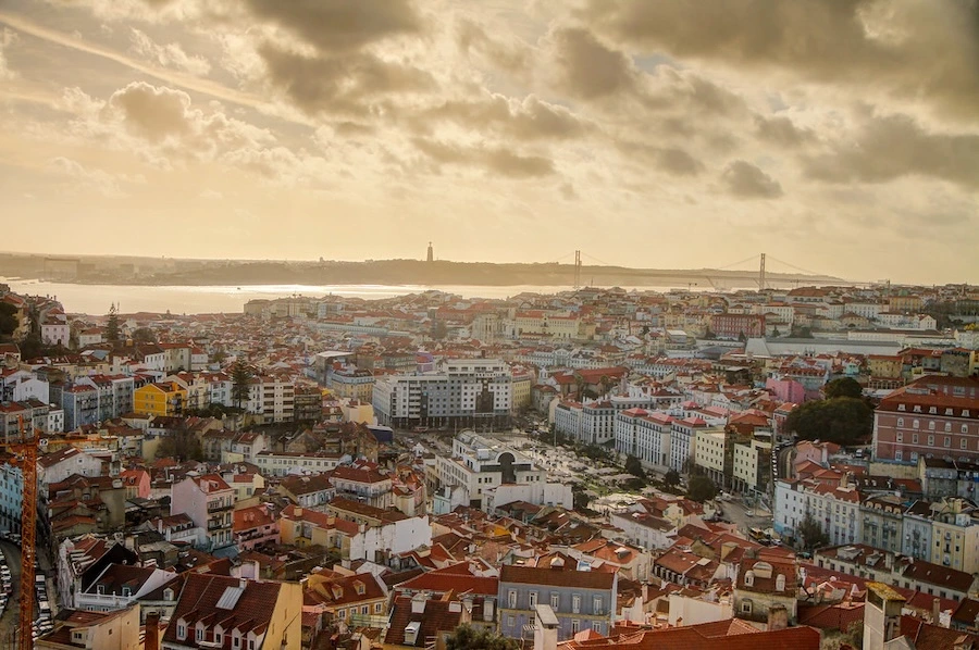 ALT: Lisboa al atardecer vista desde el Miradouro da Senhora do Monte.
