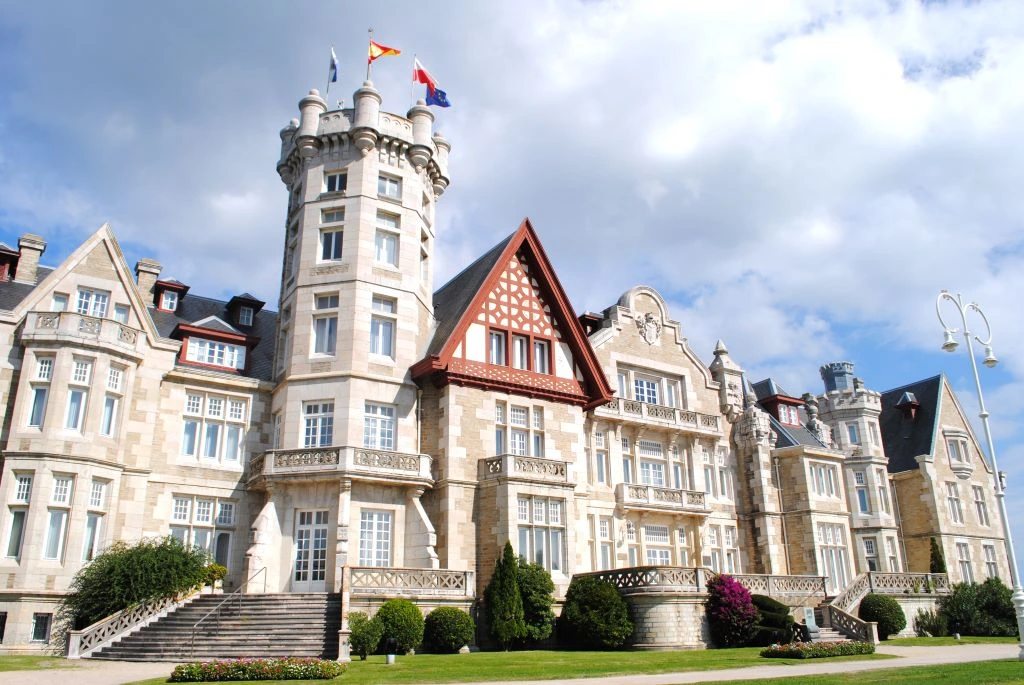 El Palacio de la Magdalena en Santander con jardines y banderas, un imprescindible en tu ruta por el norte de España.