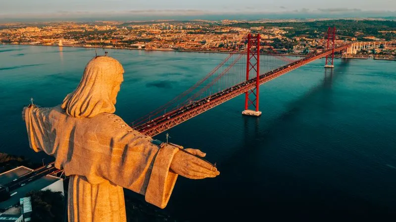 Vista panorámica de Lisboa al atardecer, mostrando el río Tajo y el Puente 25 de Abril