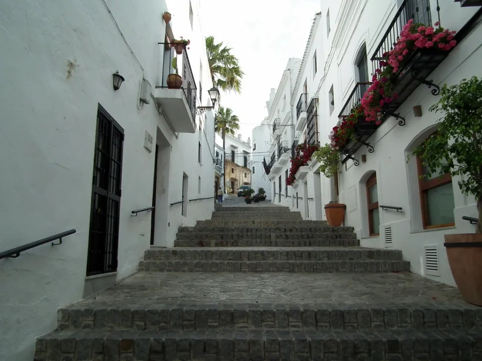 calle estrecha y empinada del pueblo de vejer de la frontera con flores en las fachadas